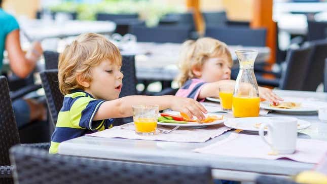Children eating at restaurant table outdoors