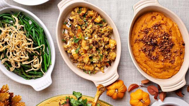 Dishes of Thanksgiving stuffing, green beans, and sweet potatoes